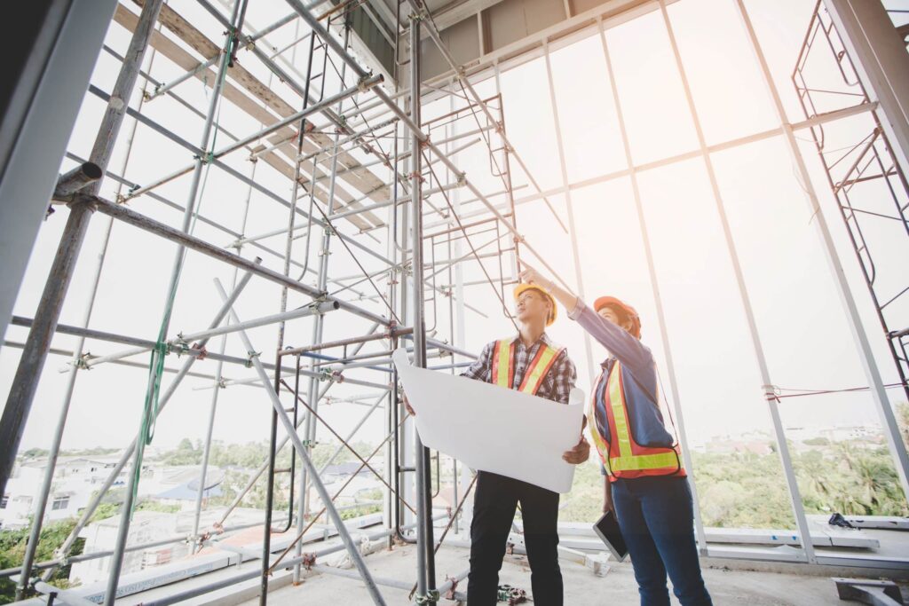 the detailed plans in their hands, discussing the project timeline and specific job tasks. In this phase of a construction project, precision is crucial to ensure accuracy in the execution of the final build.