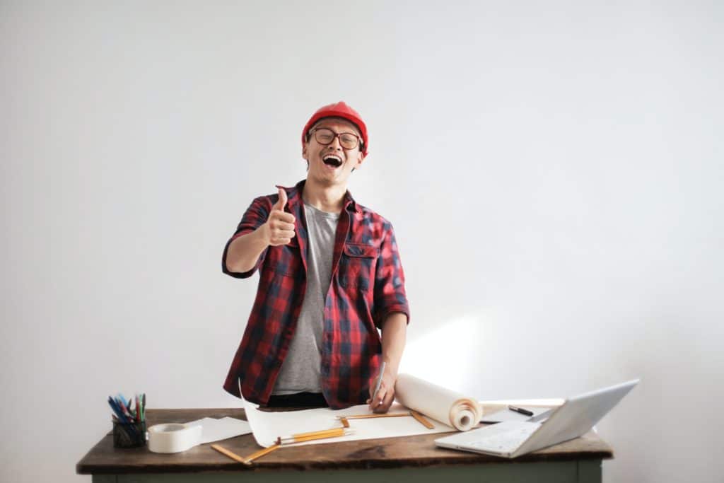 A happy construction worker with a laptop 