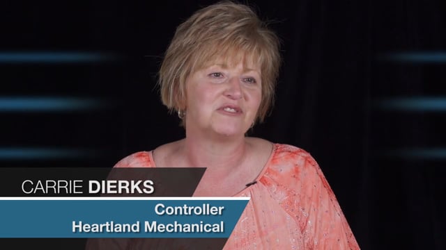 land Constructors." In another window overlaying the video, there's a screenshot of the Jonas Construction Software interface showcasing different features like job costing, devotion tracking, and GAAP compliance.

Alt text: "Video interview featuring Heartland Constructors' Controller Carrie Dierks with a displayed screenshot of Jonas Construction Software interface.