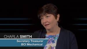 Alt text: "Charla Smith, with short dark hair and a navy blazer over a floral top, appearing in a television interview. She is identified as the secretary treasurer for BCI Mechanical.