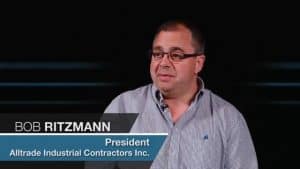 Alt text: Bob Ritzmann, the President of Alltrade Mechanical Contractors Inc., portrayed in an interview setting. He is a male individual wearing glasses and a checkered shirt.