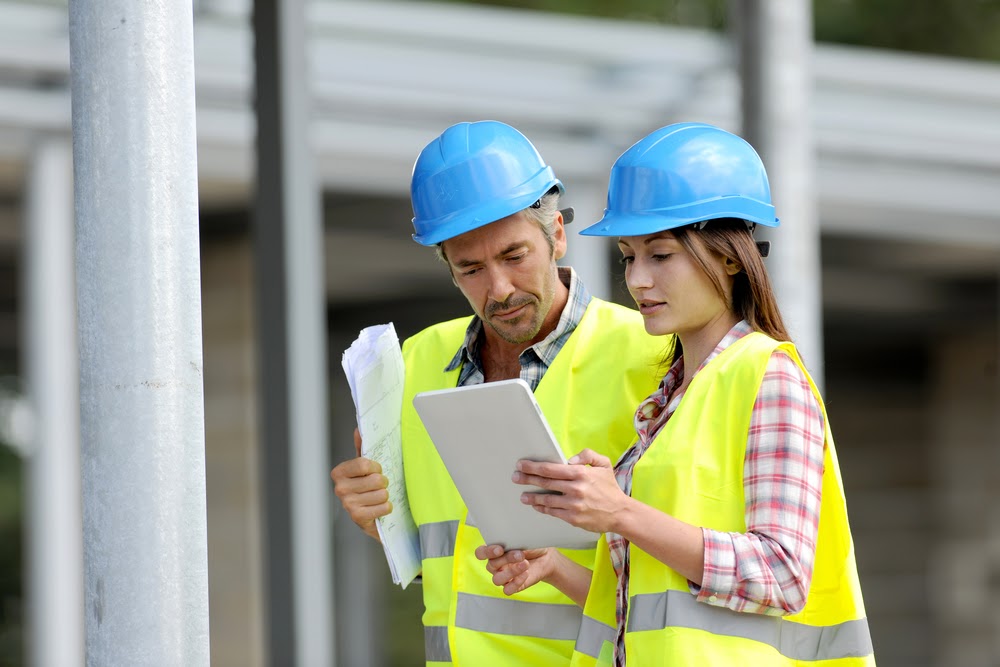 Two construction project managers looking at a tablet
