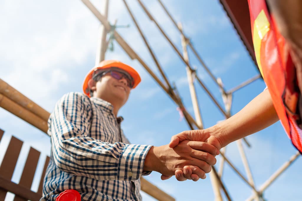 A mechanical service technician shaking hands with a customer