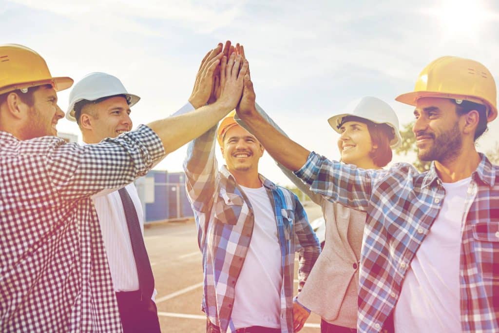 Construction workers high fiving 